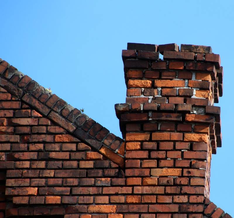 Signs Your Clinton Home Needs a Chimney Inspection Damaged chimney on an Clinton home showing cracks and missing mortar